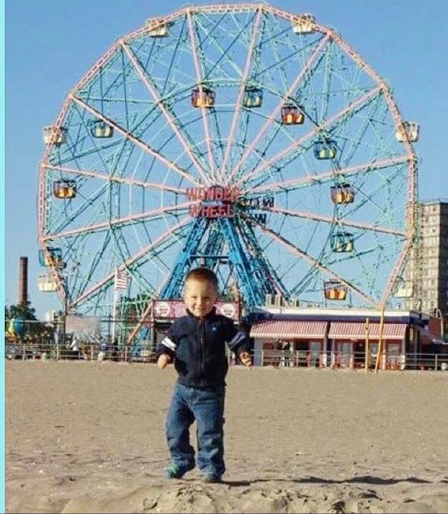 A small boy on the beach at Coney Island. 