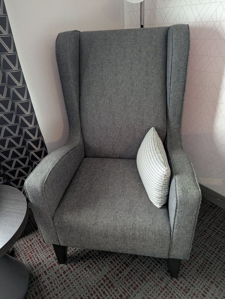 A fairly nice looking gray arm chair in the corner of our hotel room. Do not let its appearance fool you, it sucks.