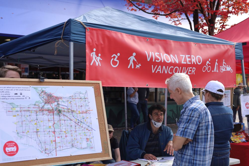vision zero tent set up at previous car free day talking to visitors. Crash map to the left.