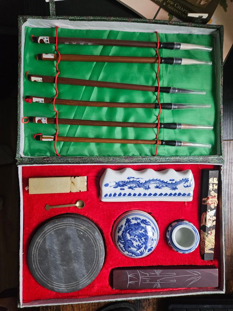 A Chinese calligraphy set with brushes and inks and porcelain accouterments. 