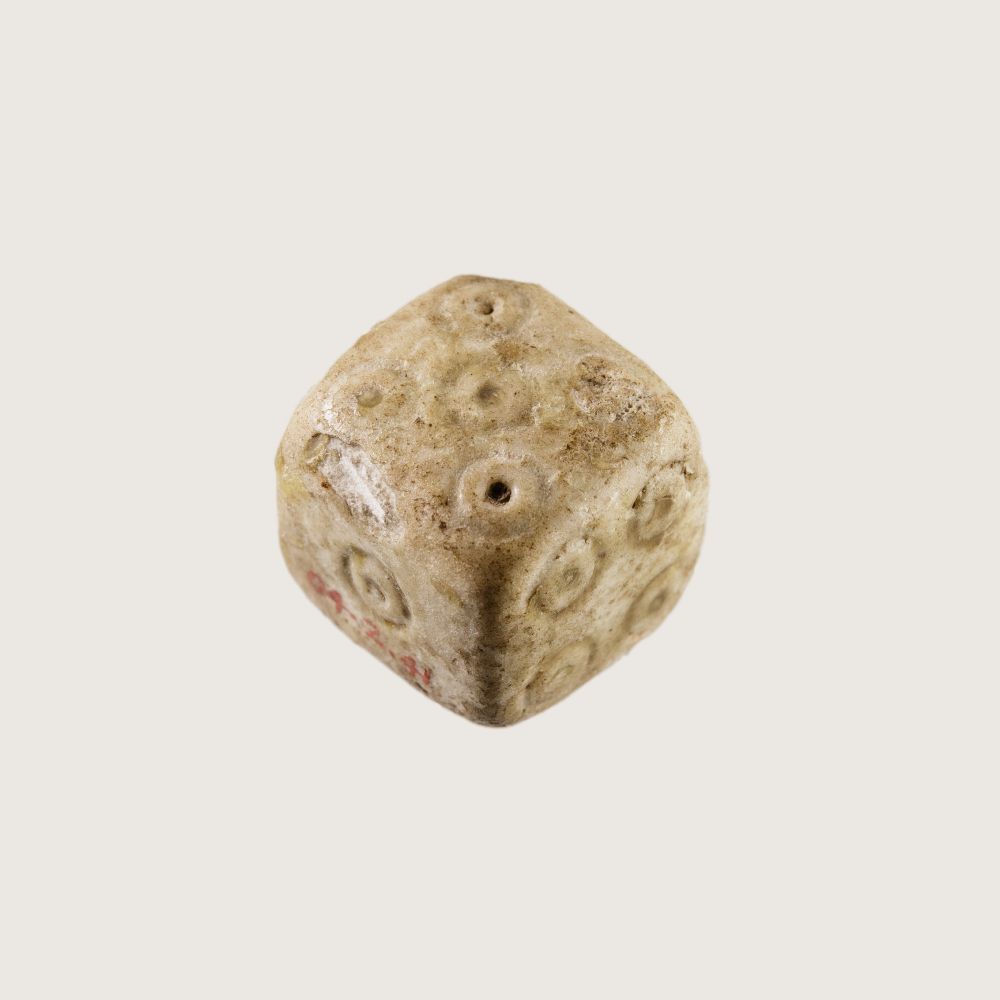An ancient roman die made of white fiance that shows five, one, and four pips -- an example of the standard pip array still in use today. https://www.metmuseum.org/art/collection/search/553788