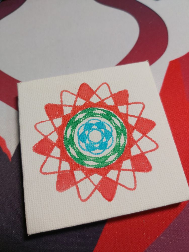The same nested spirograph pattern of red, green and blue, but with sections coloured in 