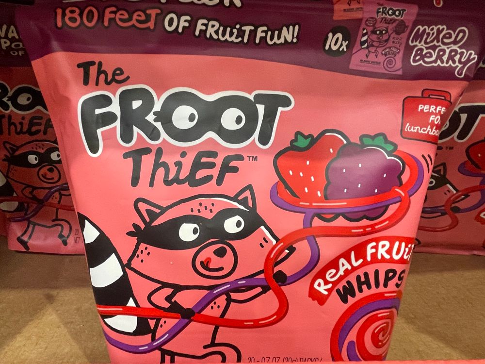 package of “Froot Thief” brand fruit snacks with a little cartoon raccoon mascot depicted stealing fruits with the fruit snack whips.