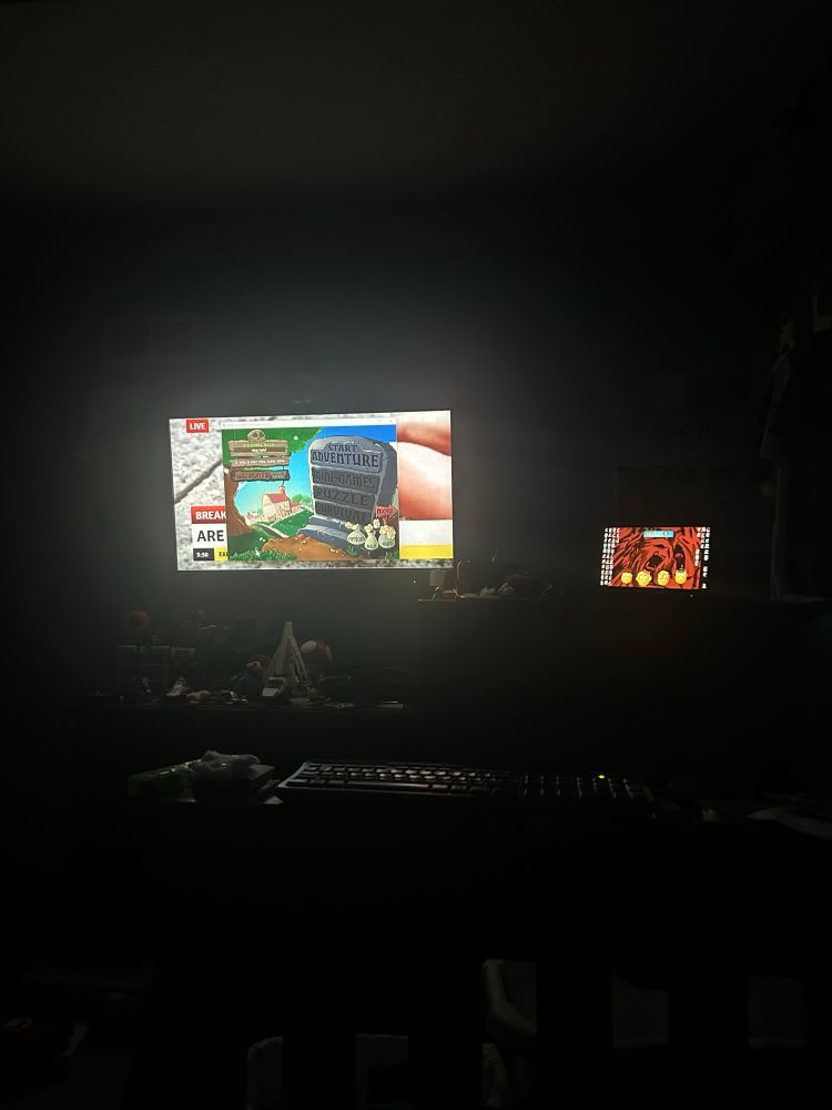 dark image where the only things you can see is my TV (which has a window of PvZ DLC mod) and my laptop (which is just showing my wallpaper )