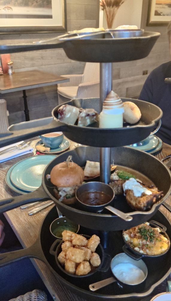 A really filling afternoon tea, mac and cheese, potato bites and coleslaw on the bottom layer, mini satay chicken burger, lamb, samosa, and fetta on the 2nd layer up, doughnut, lemon cake, and cheese cake 3rd layer up, scones on the top layer
