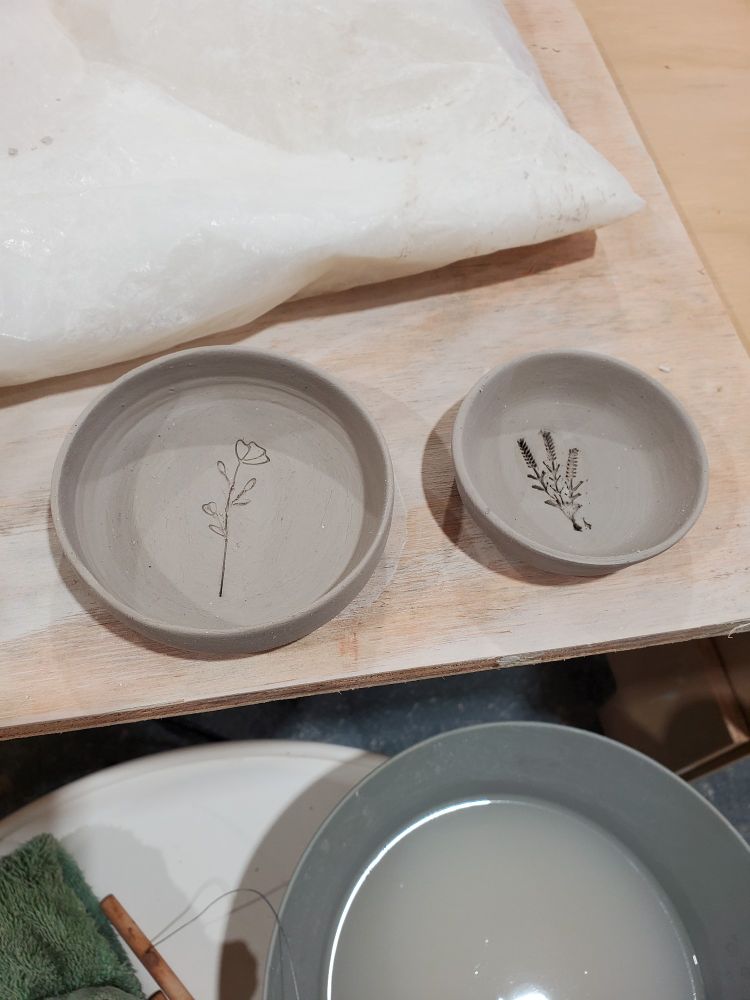 Clay trinket dishes with floral stamp imprints in the center. 