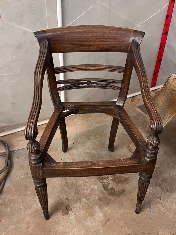Lightly sanded wooden chair frame with intricate carved details