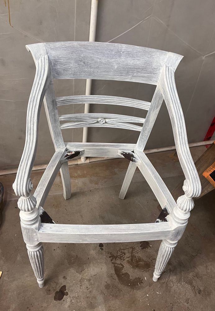 White primed wooden chair frame with intricate carved details