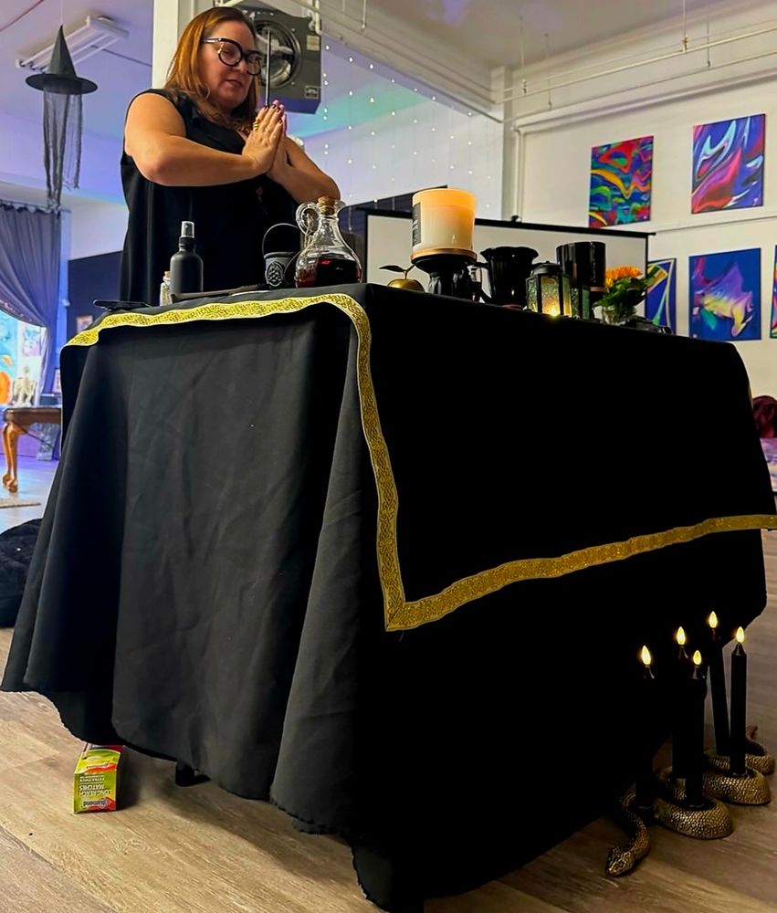 Woman standing in prayer in front of an altar.

