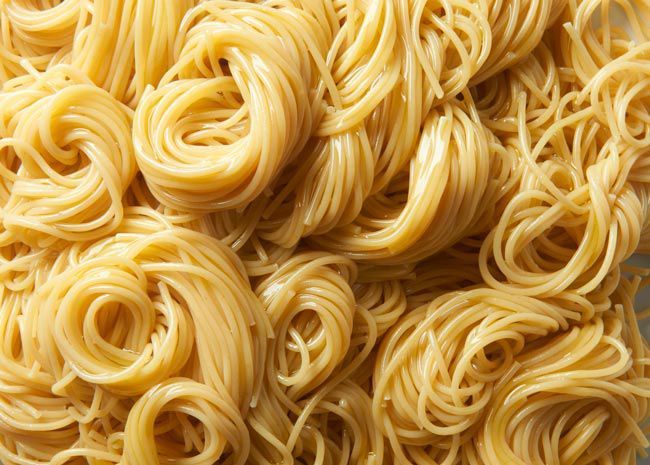 Lots of cooked spaghetti, all curled and tangled up.