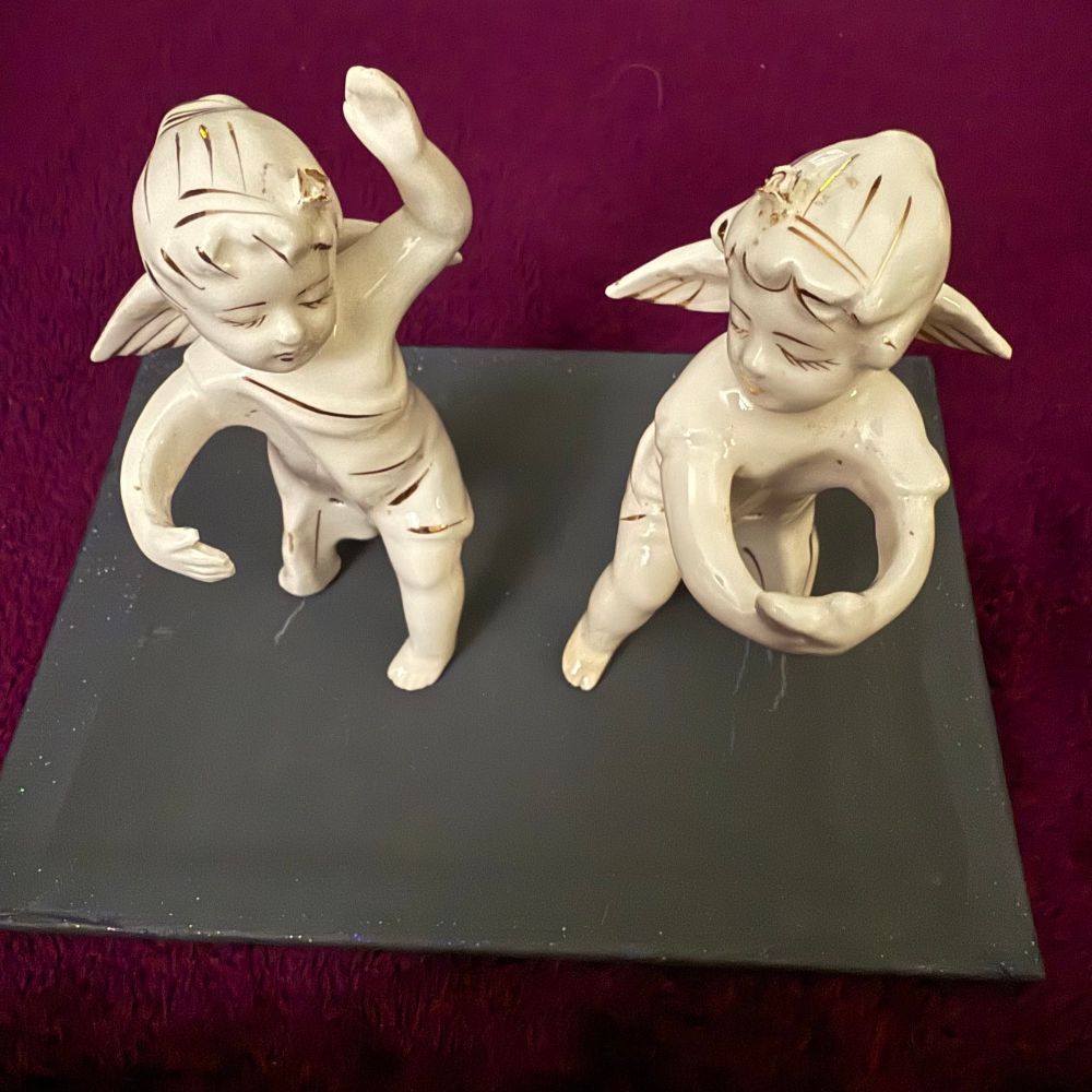Top view of weird three legged porcelain angels with gold accents