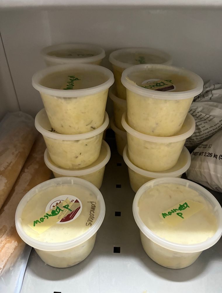Containers full of mashed potatoes in a freezer 