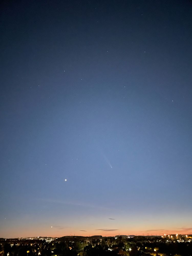 View from a hill of late sunset with a comet in the sky