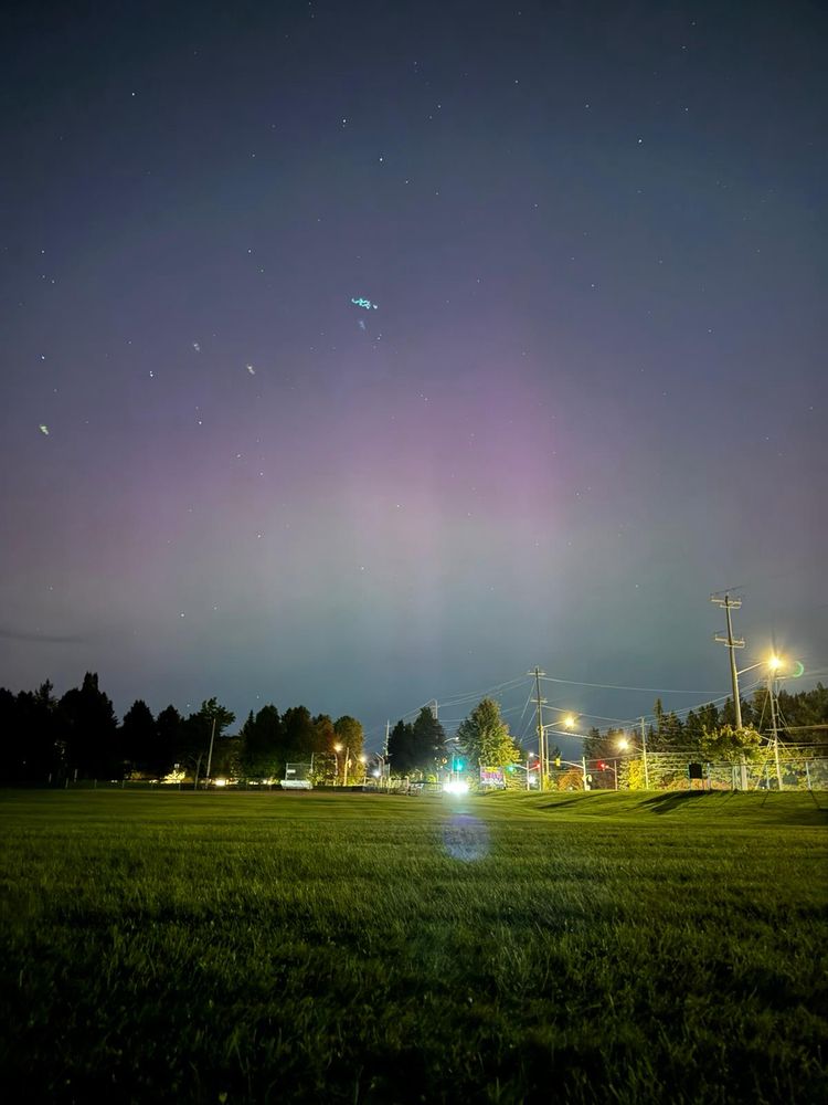 Pink and green Aurora over an over-exposed road