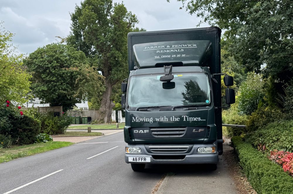 A lorry completely blocking the pavement with a metal ramp protruding from its side 