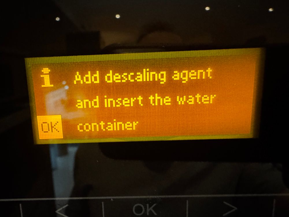 Orange letters in the display on a coffee machine 


Add descaling agent and insert the water container
OK