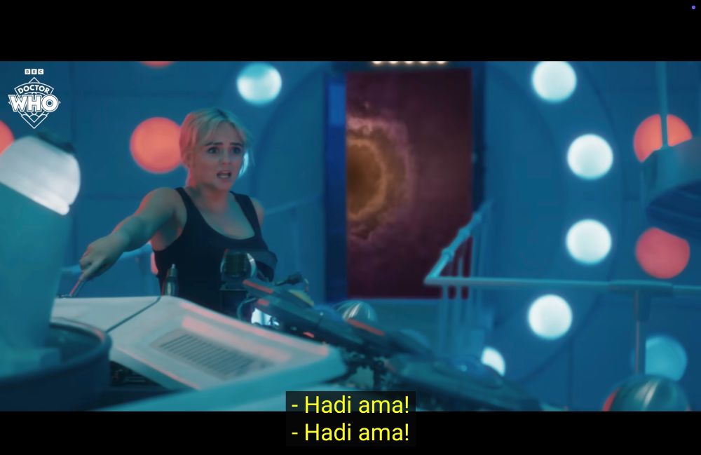 Screen from a deleted scene (released online) from Empire of Death (2024). Ruby pulls a lever on the TARDIS console. Behind her the open TARDIS door shows the time vortex. Ruby replies to the Doctor’s “Hadi ama!” with her own “Hadi ama!”

The deleted scene is available at: https://www.youtube.com/watch?v=IqQsL79UpMs on the BBC Doctor Who YouTube account.