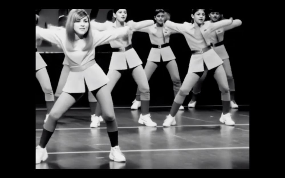 Screen from an amateur re-imagining of Doctor Who – The Macra Terror, depicting a group of AI-generated dancers. There are no such things as hands.