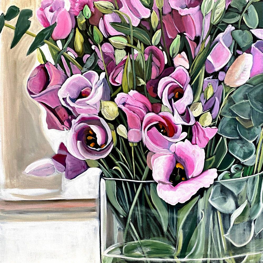 A vibrant painting of a bouquet of lisianthus flowers in a clear glass vase. The flowers are in various shades of pink, purple, and white, with soft, delicate petals that curl outward. Green stems and leaves fill out the arrangement, with a few eucalyptus leaves adding texture. The background is softly blurred in neutral beige and white tones, giving the focus entirely to the vivid floral display.