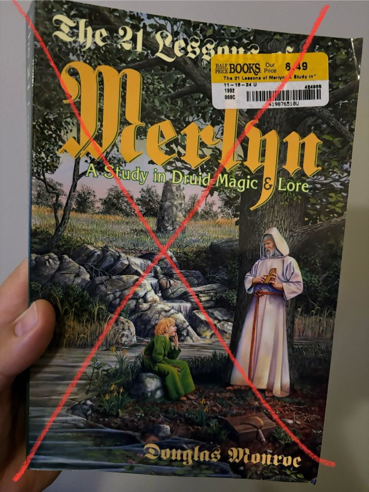 Photo of the book “The 21 Lessons of Merlyn” by Douglas Monroe, with a big red X added to the photo in condemnation 