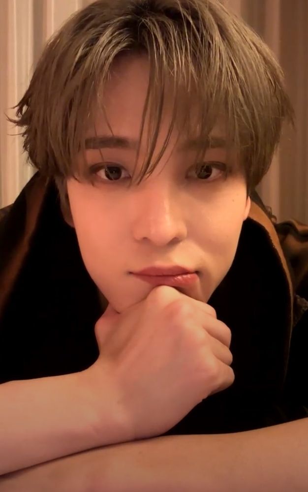 A screencap from a relatively recent live. Yunho is resting his chin on his fist and leaning on his arms. He's got the sandy brown hair. He's looking at us with a pitiful, soulful look with a mild smoky eye. 