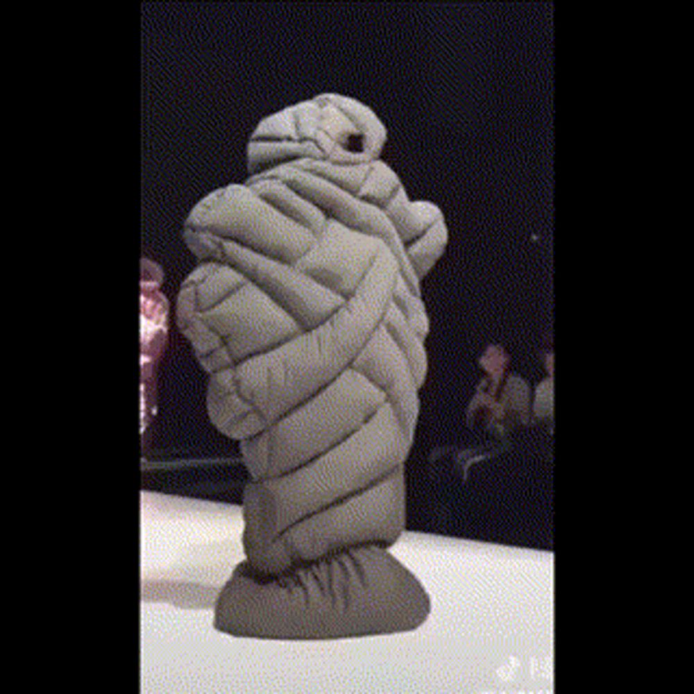 a statue of a person wrapped in a blanket standing on a stage .