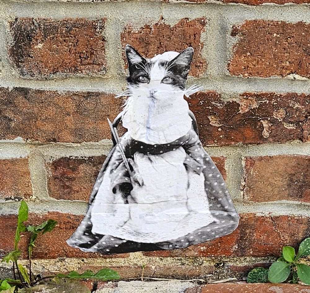 Small cat in a dress, and painting smock - a mural located on main street in Grinnell, Iowa.