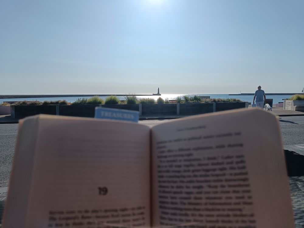 Picture of a book and the sea with a clear blue sky at Roker beach, northeast england 