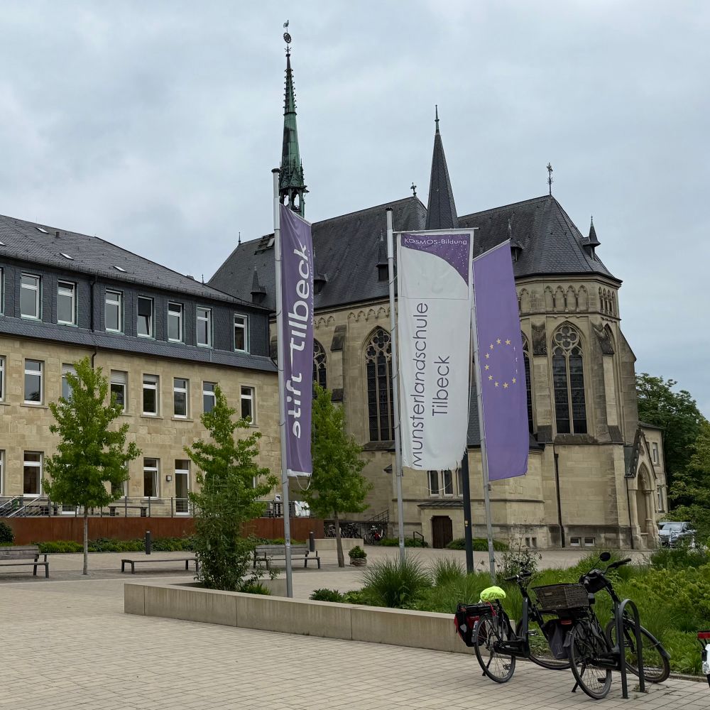 Fassade des Stift Tilbeck mit Fahnen im Vordergrund