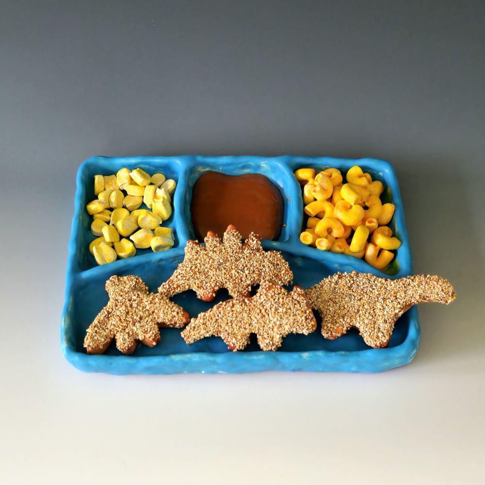 Ceramic sculpture of kid cusine frozen dinner with Dino nuggets, brownie, corn & mac & cheese