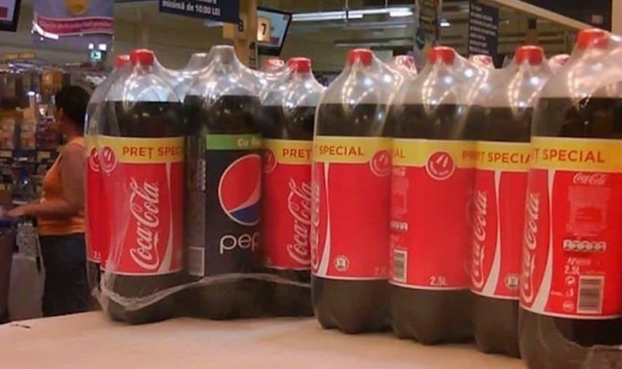 A single Pepsi bottle among several Coca-Cola bottles. 