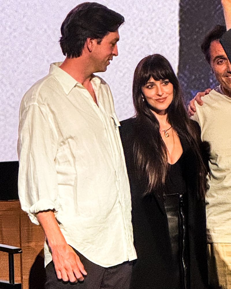 Nicholas Braun looking down at Dakota Johnson