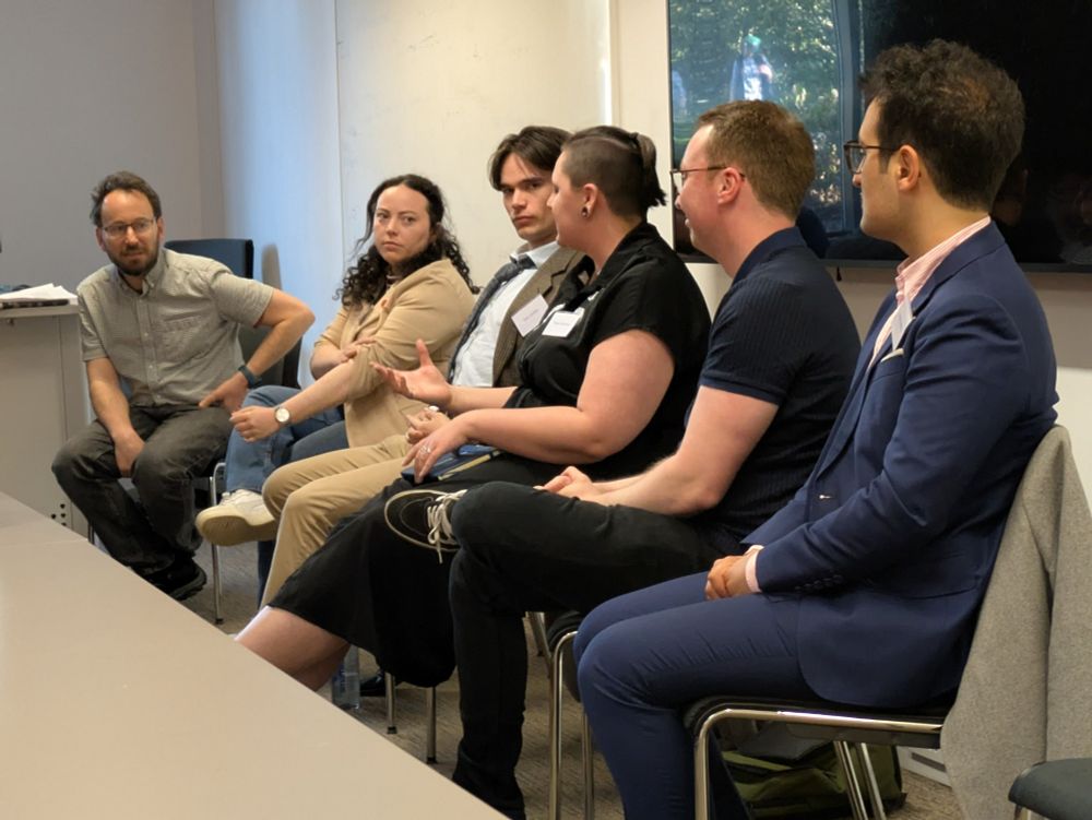 A panel of 5 alumni listen as the person in the centre speaks, gesturing with their hand. Professor James Sloam is leaning in intently.