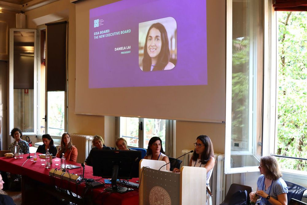 Dr Lai speaking in front of a microphone, with a screen in the background stating that she is the new EISA president