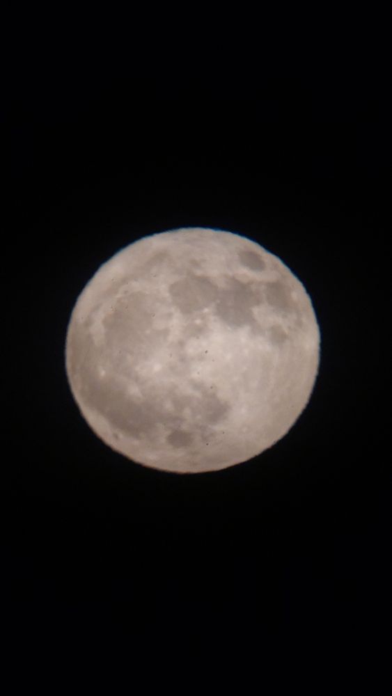 Photo of a full moon through a telescope.