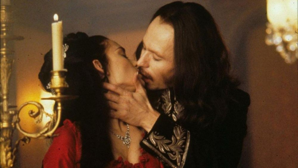 still from bram stoker’s Dracula (1992) of Mina being seduced by Dracula in his young form in candlelight 