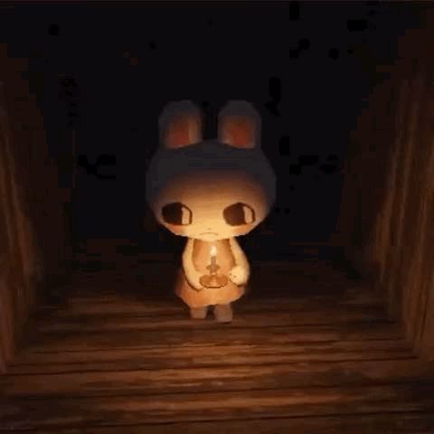 a bunny is holding a candle in a dark room .