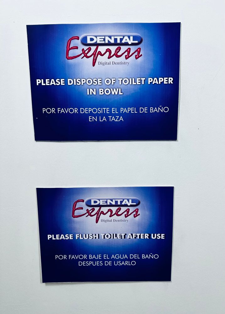 Signs on a bathroom stall wall instructing people to flush their toilet paper, which is unusual in some places in Mexico 