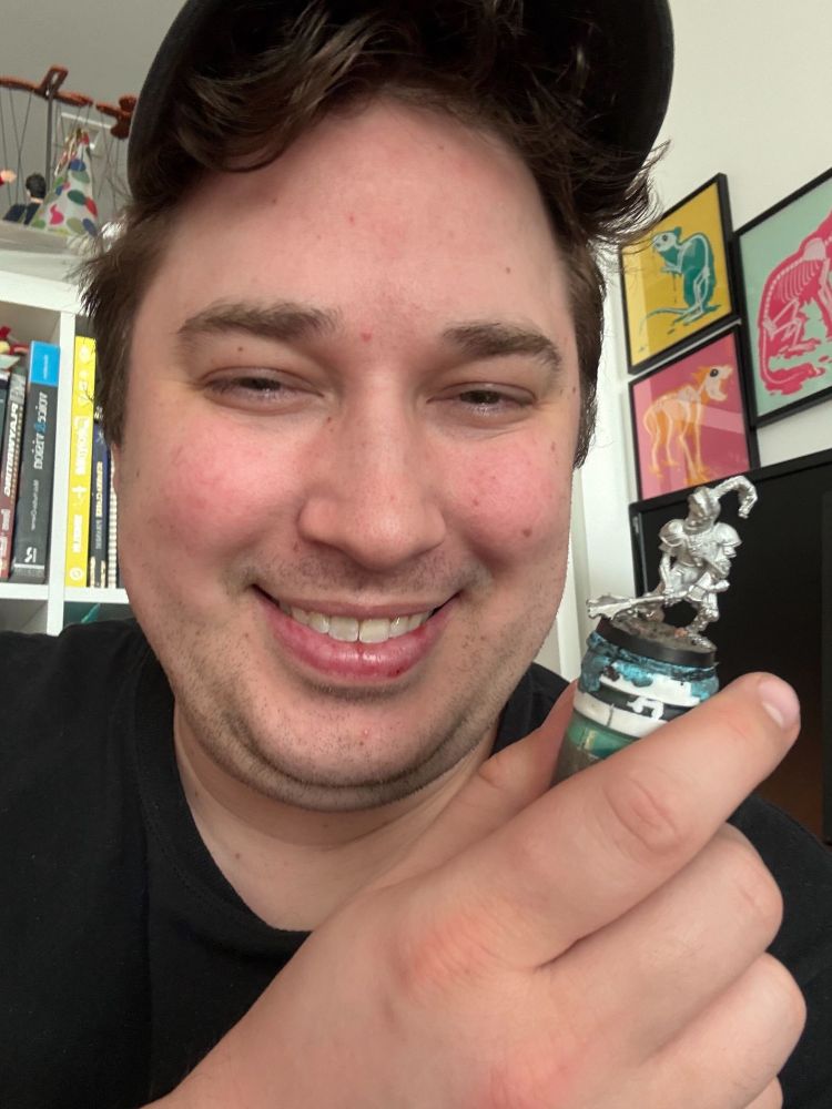 Man holding a knight miniature.