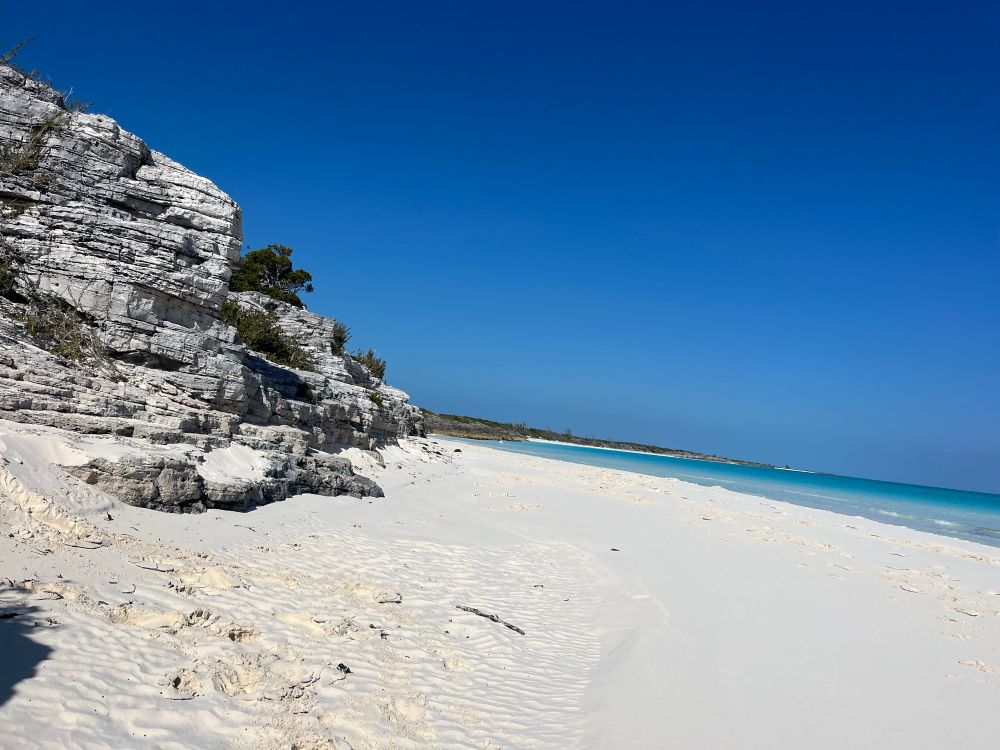Beach with rocks and blue water. Shroud Cay, Bahamas.