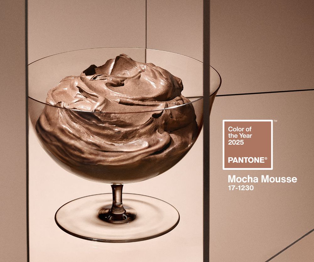 A glass bowl full of brown pudding on a background of light brown panels and branding for Pantone's 2025 color of the year Mocha Mousse