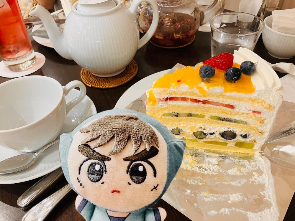 紅茶とフレッシュフルーツケーキの写真に中在家長次のぬいぐるみの写真をコラージュしている
