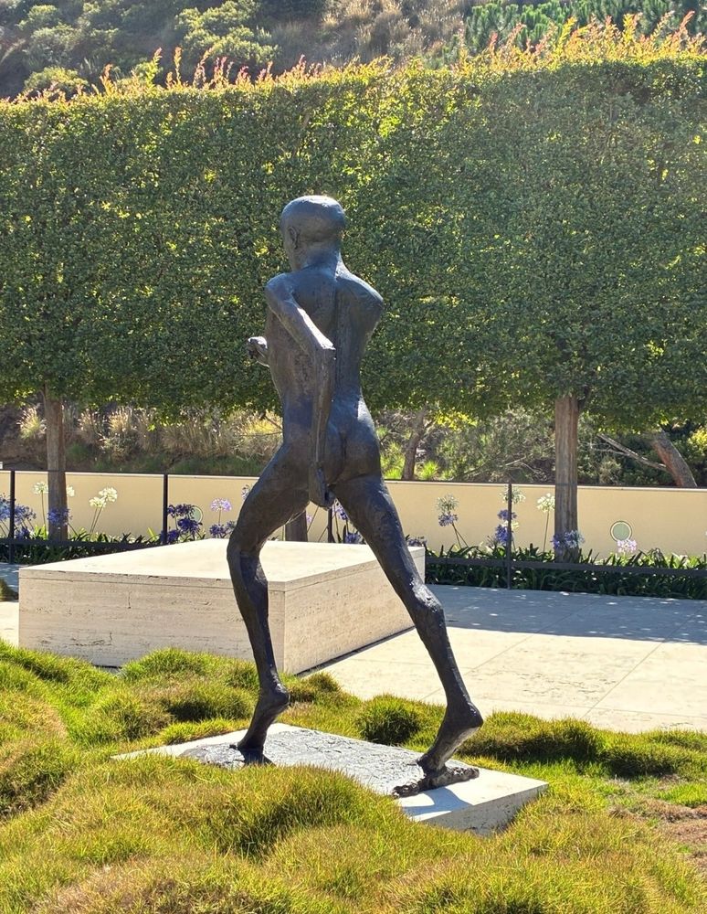 A bronze sculpture of a figure in the motion of running 