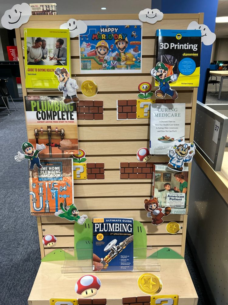 library display of every aspect of mario’s world: doctor mario with medicare; plumber luigi; maker space 3D printing. 
