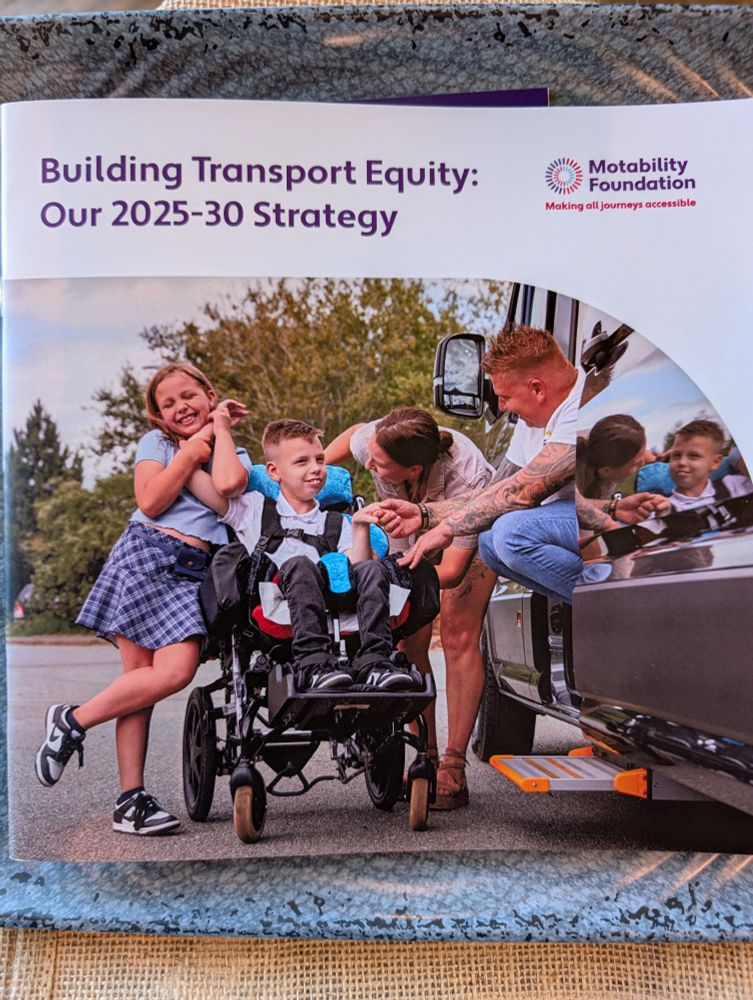 Cover of strategy document. Picture of a child in a wheelchair with his family around him by a van.