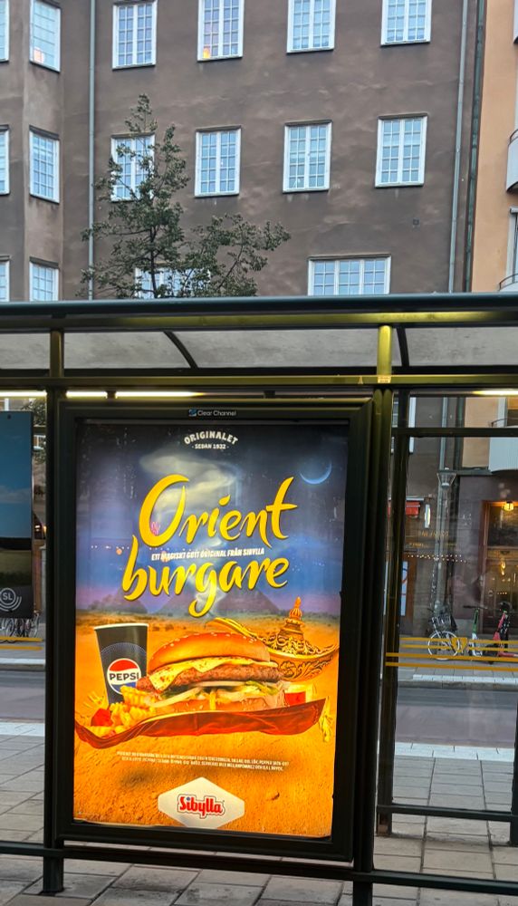 Reklamaffisch för sibyllas ”orient burgare”, illustrerad med burgare på flygande matta. 