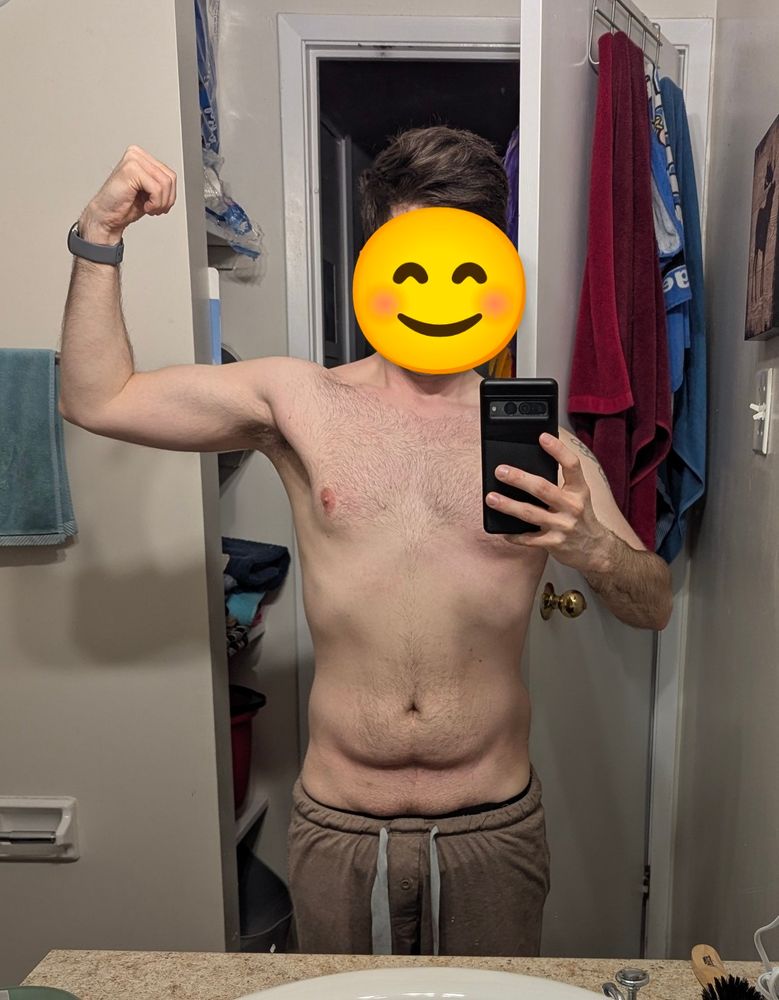 Shirtless male flex right arm with the smiley face emoji cover his face. 