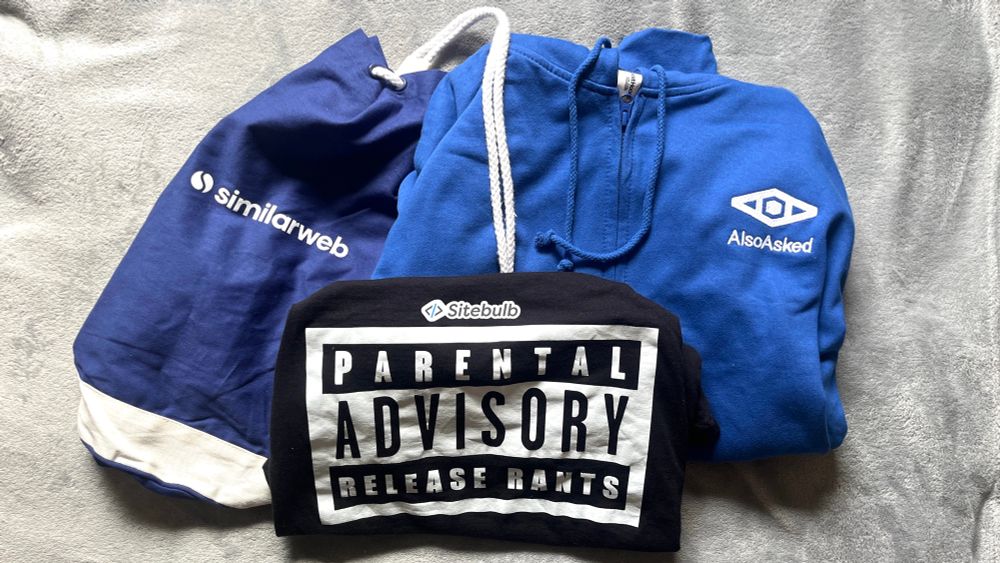 photo of clothes folded and laid out next to each other - similarweb gymbag, sitebulb tshirt saying: parental advisory - release rants, and also asked hoodie