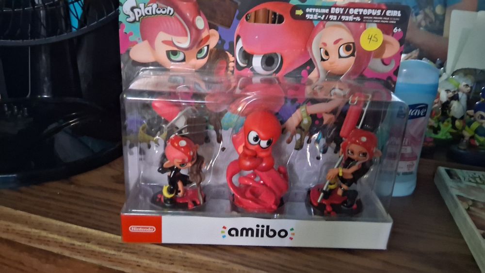 Amiibo of octoling boy holding a brush, octopus, and octoling girl holding an e-liter in package