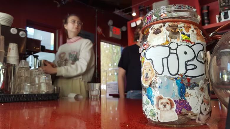 Server stands in background, with jar for tips in foreground.